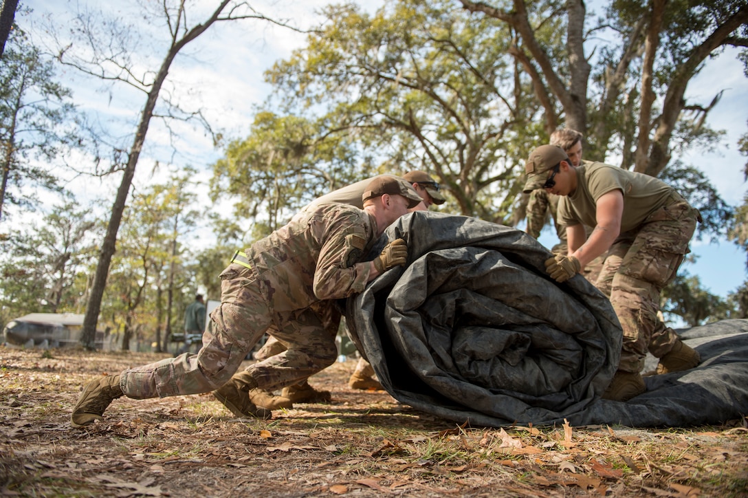 Airmen from the 621st Contingency Response Wing work together to roll and pack up a deflated air beam tent for camp tear-down during the redeployment process of Exercise Turbo Distribution at Fort Stewart-Hunter Army Airfield, Georgia, Feb. 14, 2020. Members of the 621st CRW have partnered with the U.S. Army 689th Rapid Port Opening Element and Defense Logistics Agency Rapid Deployment Team to become a Joint Task Force-Port Opening unit capable of deploying to provide mobility options and facilitating humanitarian and disaster relief assistance. (U.S. Air Force photo by Staff Sgt. Sarah Brice)