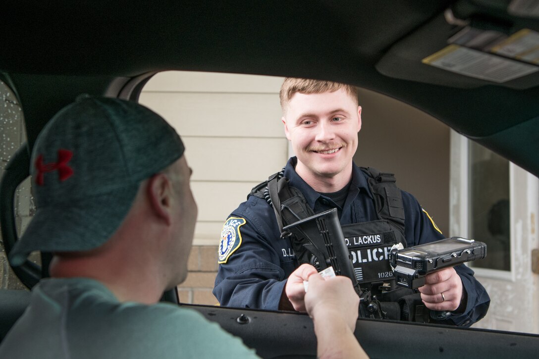 Officer Dillon Lackus, 436th Security Forces Squadron Department of the Air Force police officer, checks identification cards at the Eagle Heights housing gate, Feb. 13, 2020, at Dover Air Force Base, Delaware. Although they are most noticeably engaged in installation entry control or  base patrols, DAF police officers are fully integrated into all sections of the 436th SFS. (U.S. Air Force photo by Mauricio Campino)