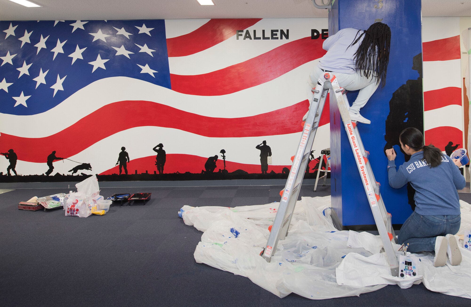 (Left to right) Airman 1st Class Te’Anne Dailey, and Airman 1st Class Deborah Kang, both 374th Security Forces Squadron patrolman, paint a mural at a main lobby of SFS’s building at Yokota Air Base, Japan, Feb. 7, 2020.