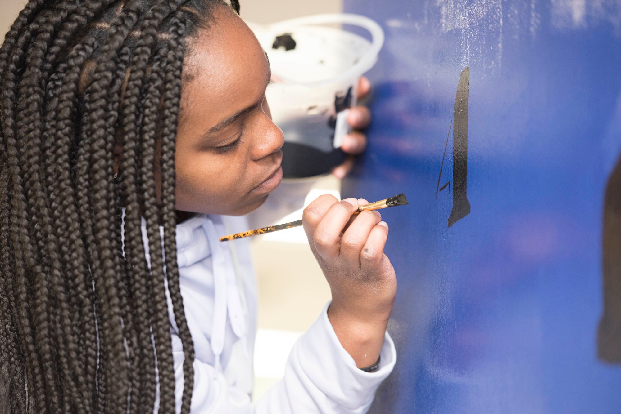 Airman 1st Class Te’Anne Dailey, 374th Security Forces Squadron patrolman, paints a mural at a main lobby of SFS’s building at Yokota Air Base, Japan, Feb. 7, 2020.