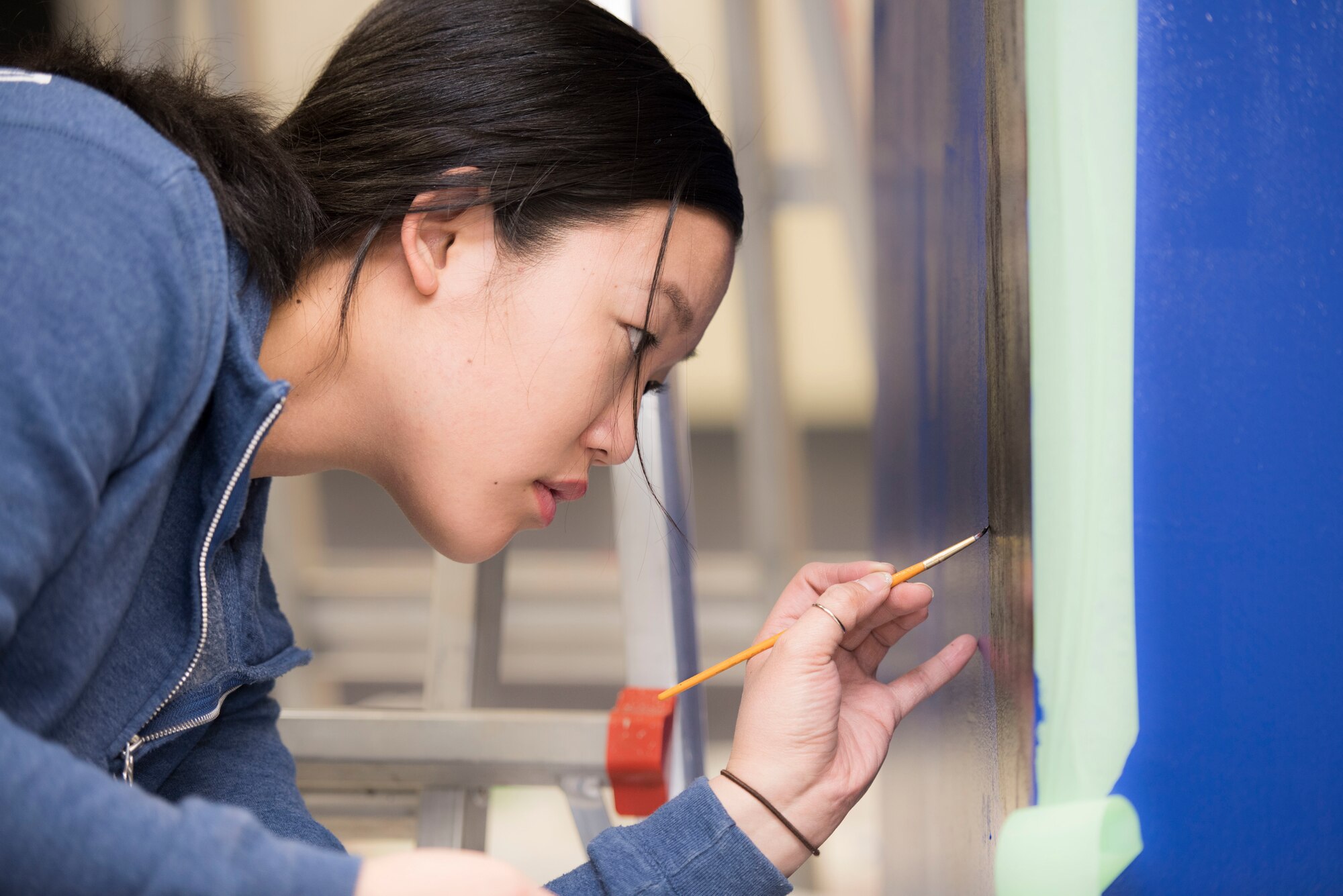 Airman 1st Class Deborah Kang, 374th Security Forces Squadron patrolman, paints a mural at a main lobby of SFS’s building at Yokota Air Base, Japan, Feb. 7, 2020.
