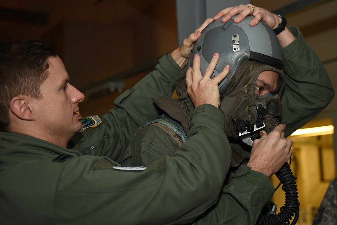 Aircrew assigned to the 48th Fighter Wing assist one another in donning mission-oriented protective posture gear during an Aircrew Contamination Control Area training exercise at Royal Air Force Lakenheath, England, Feb. 21, 2020. The training is conducted to ensure pilots and weapons systems officers can maintain mission readiness under any adverse conditions. (U.S. Air Force photo by Airman 1st Class Jessi Monte)
