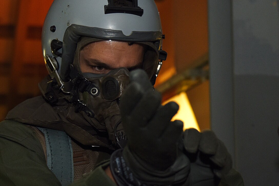 Capt. Erling German puts on flight gloves during an Aircrew Contamination Control Area training exercise at Royal Air Force Lakenheath, England, Feb. 21, 2020. The training is conducted to ensure aircrews can maintain mission readiness under any adverse conditions. (U.S. Air Force photo by Airman 1st Class Jessi Monte)
