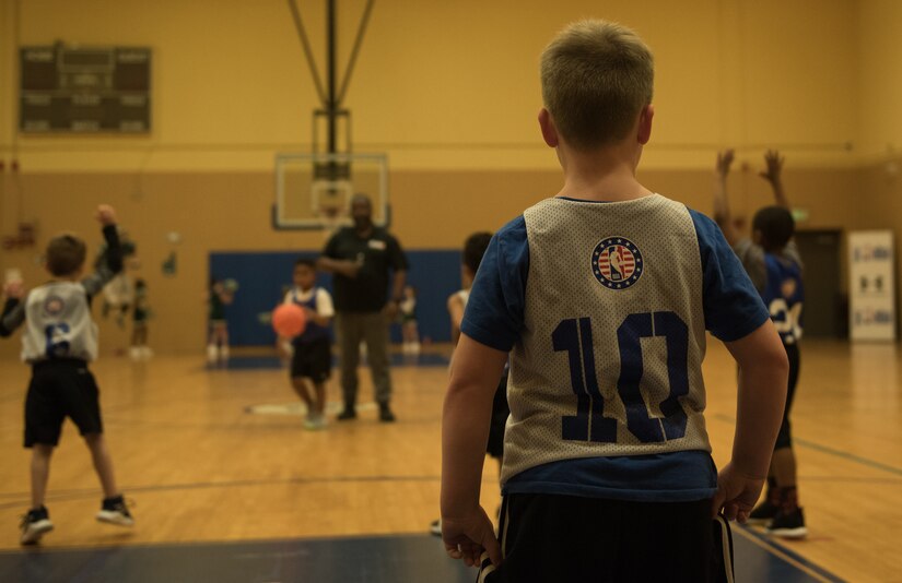 A member of a basketball team waits on defense for a member of the opposing team to dribble down the court at the Youth Sports Center, Feb. 21, 2020. Sports can encourage a lifetime of fitness and health. (U.S. Air Force photo by Airman 1st Class Sarah Dowe)