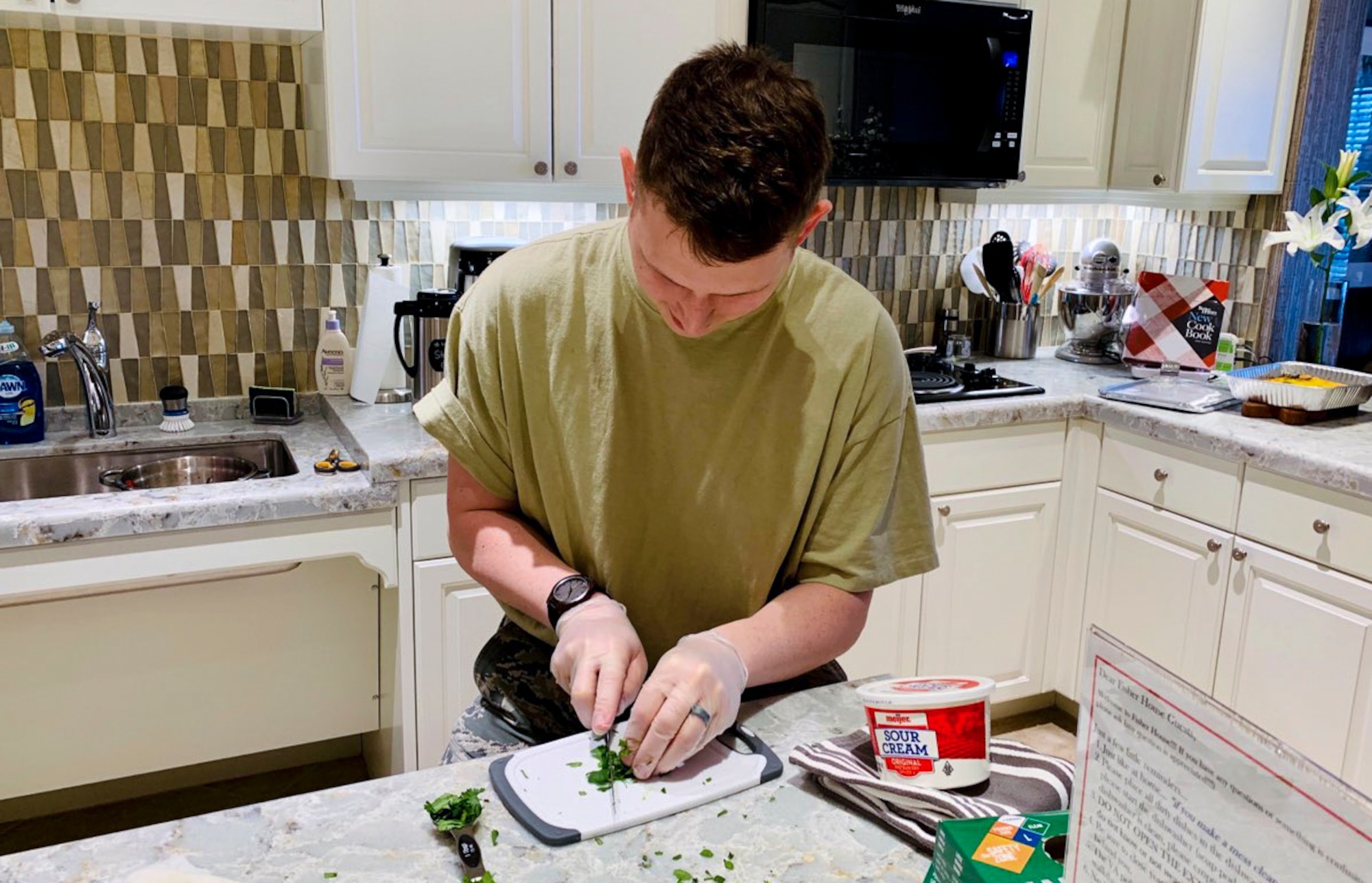 Senior Airman Aidan Hurley, Geospatial Intelligence Analysis Squadron member, prepares a meal to serve at the Veterans Administration Medical Center Fisher House in Dayton, Ohio on Feb. 20, 2020. During the volunteer event, six members of the Geospatial Intelligence Analysis Squadron bought, prepared and cooked meals for veterans located at the medical center. (U.S. Air Force photo/Courtesy)