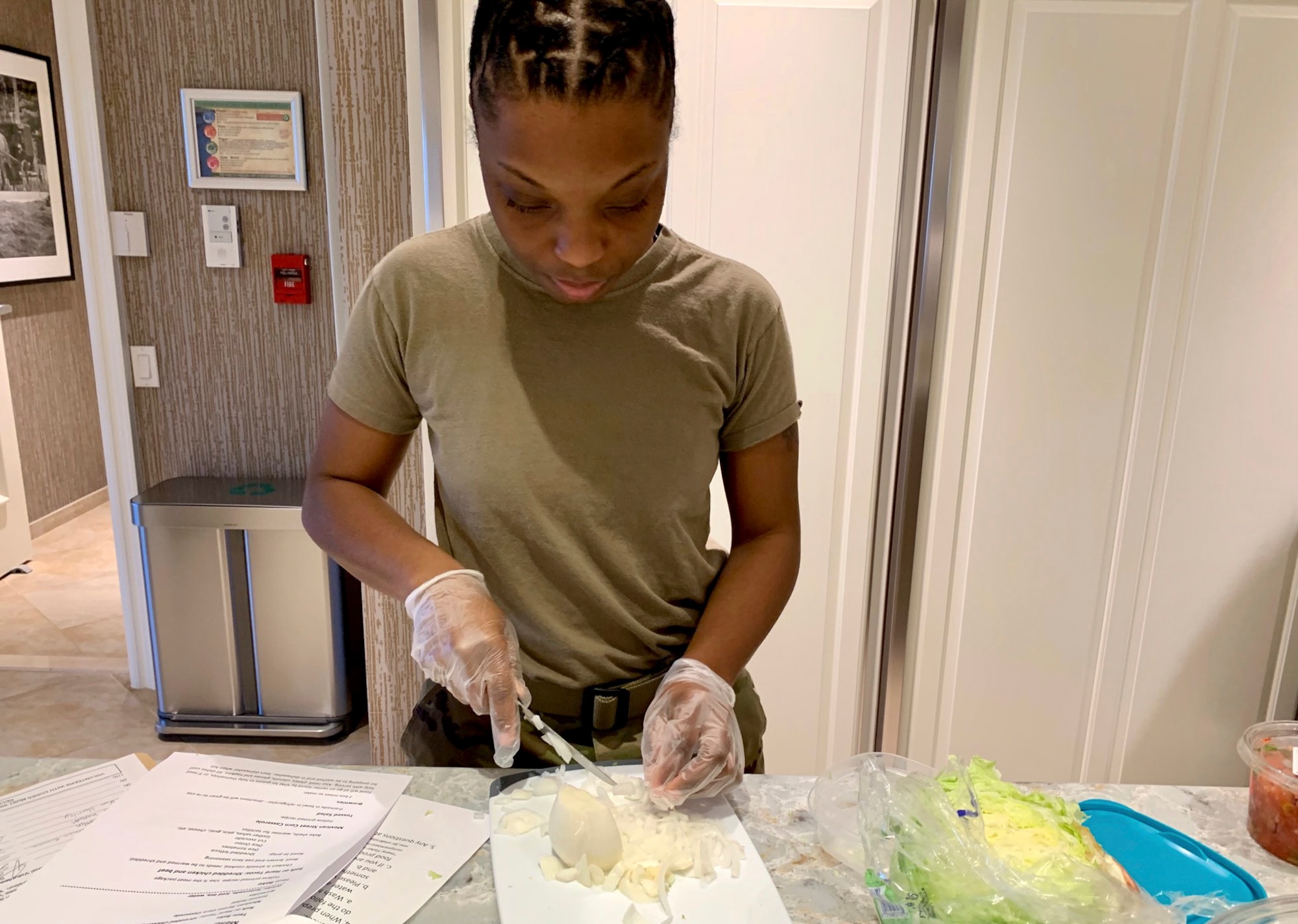 Senior Airman Miyae Franklin, Geospatial Intelligence Analysis Squadron member, prepares a meal to serve at the Veterans Administration Medical Center Fisher House in Dayton, Ohio on Feb. 20, 2020. During the volunteer event, six members of the Geospatial Intelligence Analysis Squadron bought, prepared and cooked meals for veterans located at the medical center. (U.S. Air Force photo/Courtesy)
