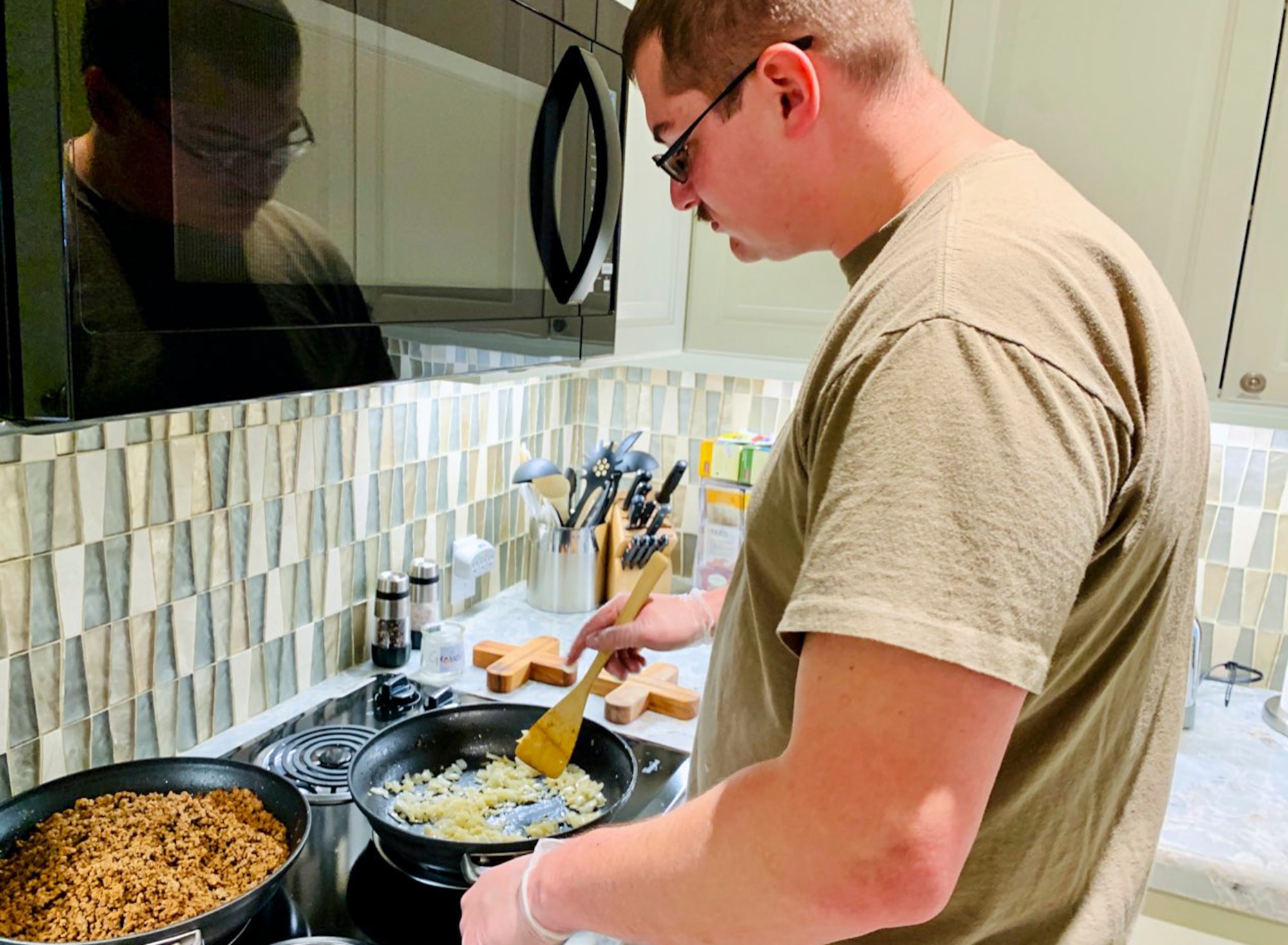 Tech. Sgt. Dustin Krasovic, Geospatial Intelligence Analysis Squadron member, cooks food at the Veterans Administration Medical Center Fisher House in Dayton, Ohio on Feb. 20, 2020. During the volunteer event, six members of the Geospatial Intelligence Analysis Squadron bought, prepared and cooked meals for veterans located at the medical center. (U.S. Air Force photo/Courtesy)