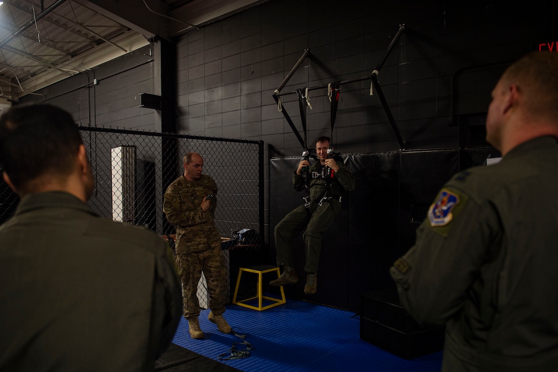 Photo of a survival, evasion, and resistance, escape specialist specialist explaining emergency parachute procedures.