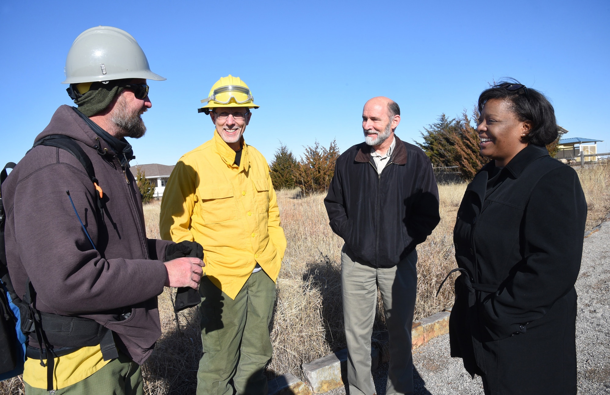 Nathan Suida, the "burn boss" from the Wildlife Fire Center, San Antonio Wildland Fire Module, left, speaks with John Krupovage, Natural Resources; Keith Buehler, 72nd Civil Engineering installation management division chief and 72nd CE Director Stephanie Wilson during a prescribed burn at the Scissortail Trails area Feb. 13. Wilson oversees all aspects of civil engineering on Tinker, ranging from the Tinker Fire Departments, roads and facilities across the installation to the natural preservation of the base. (U.S. Air Force photo/Kelly White)