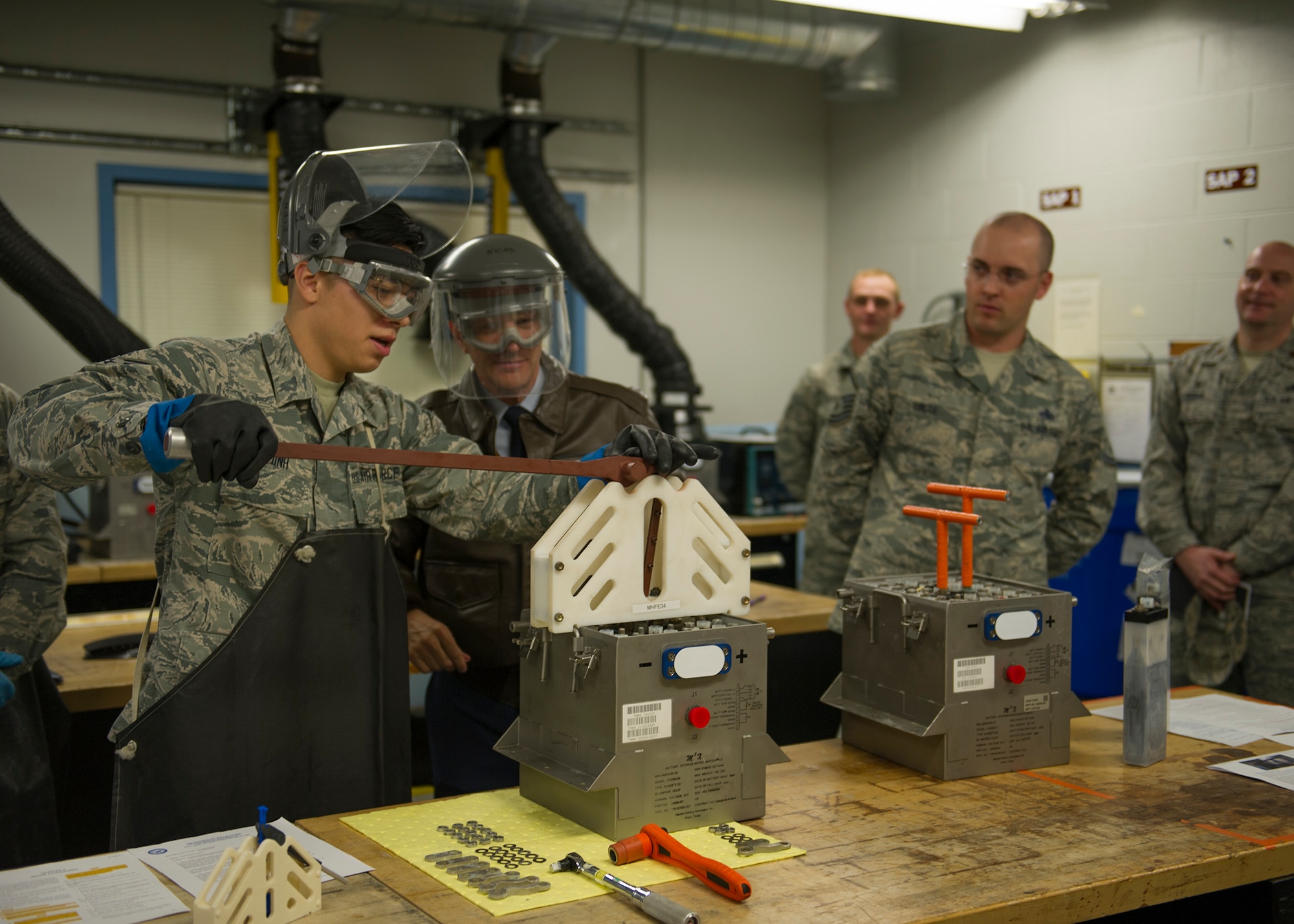 U.S. Air Force Senior Airman Brandon Dinh, 446th Maintenance Squadron (MXS) electrical and environmental technician, demonstrates how to operate a battery cell extracting device to Maj. Gen. Randall Ogden, commander of the 4th Air Force, U.S. Air Force Reserve Command, on McChord Field, Washington, Oct. 6, 2019. The innovative battery cell extractor, designed by members of the 446th MXS, was assembled and tested to provide a safer and more effective workflow when extracting battery cells. (U.S. Air Force photo by Senior Airman Christopher Sommers)