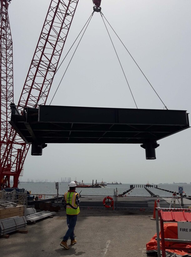 A contractor working for the U.S. Army Corps of Engineers Middle East District oversees installation of a steel module during construction of a new Navy pier in Bahrain.