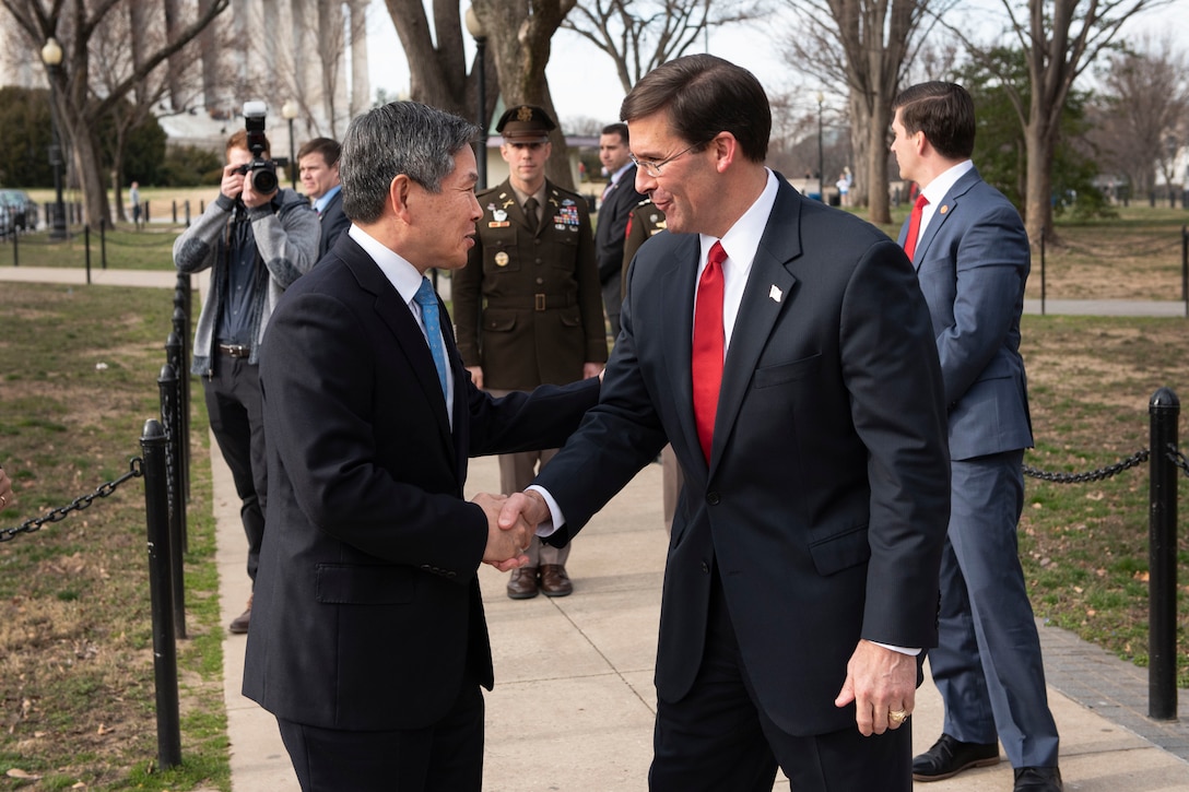 Two men shake hands.