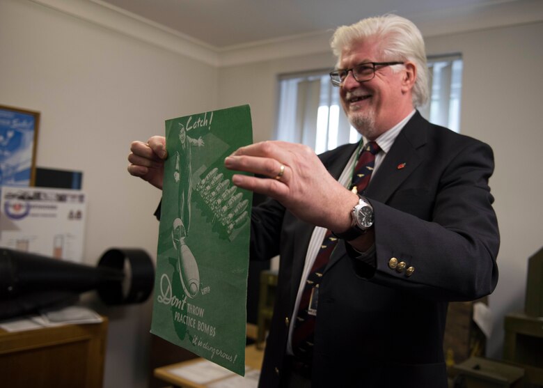 Jim Blackwood, events coordinator, holds a poster about safe practice bomb handling at The Pathfinder Collection at the Wyton Heritage and Conference Centre, RAF Wyton, England, Feb. 21, 2020. The 501st Combat Support Wing 2019 Annual Award nominees and guests attended the museum to learn more about Pathfinder heritage in honor of the Year of the Pathfinder 2020 initiative. (U.S. Air Force photo by Airman 1st Class Jennifer Zima)