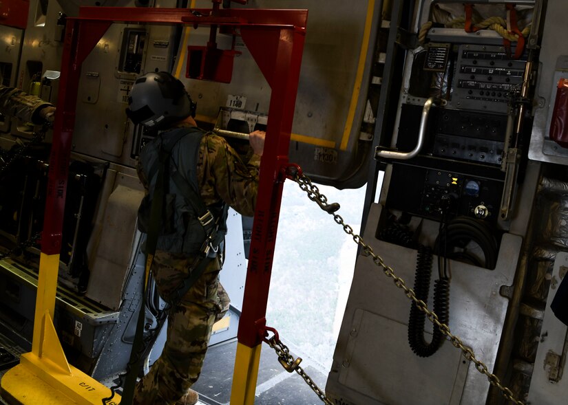 Staff Sgt Johnathan Fishel, a C-17 Globemaster III loadmaster assigned to the 15th Airlift Squadron at Joint Base Charleston, S.C., opens the cargo door in preparation for an air drop over Pope Army Airfield, N.C., Feb. 20, 2020.