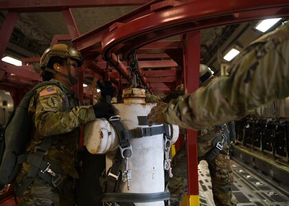 Sgt. 1st Class Katherine Greene, a test parachutist assigned to the Airborne and Special Operations Test Directorate at Fort Bragg, N.C., moves a mannequin to the ready position for an air drop onboard a C-17 Globemaster III over Pope Army Airfield, N.C., Feb. 20, 2020.