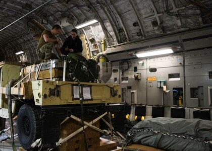 Staff Sgt. Johnathan Fishel, a C-17 Globemaster III loadmaster assigned to the 15th Airlift Squadron at Joint Base Charleston, S.C., and Technical Sgt. Casey Bradley, a loadmaster assigned to the Airborne and Special Operations Test Directorate at Pope Army Airfield, N.C., rig a humvee for an air drop at Pope Army Airfield, N.C., Feb. 19, 2020.