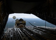 A loadmaster ejects a humvee out of a C-17 Globemaster III over Pope Army Airfield, N.C., Feb. 19, 2020.