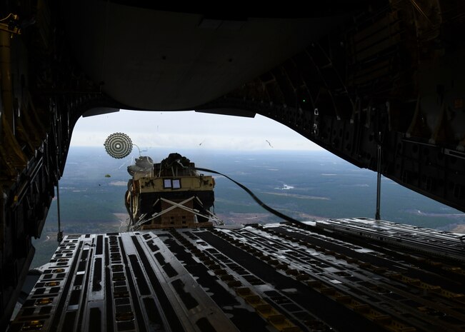A loadmaster ejects a humvee out of a C-17 Globemaster III over Pope Army Airfield, N.C., Feb. 19, 2020.