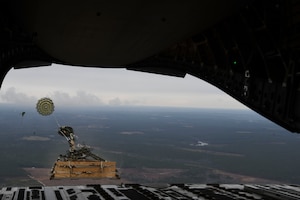 A loadmaster ejects a humvee out of a C-17 Globemaster III over Pope Army Airfield, N.C., Jan. 19, 2020. Airmen from the 15th AS integrated with the ABNSOTD to conduct air drop training for both services.