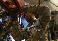 Sgt. 1st Class Jonathan Reed, an operations NCO assigned to the Airborne and Special Operations Test Directorate at Fort Bragg, N.C., prepares a mannequin rack for an air drop mid-flight on a C-17 Globemaster III over Pope Army Airfield, N.C., Feb. 20, 2020.