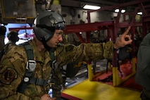 Staff Sgt Johnathan Fishel, a C-17 Globemaster III loadmaster assigned to the 15th Airlift Squadron at Joint Base Charleston, S.C., gives a jump master the, “one minute before drop” hand sign over Pope Army Airfield, N.C., Feb. 20, 2020.