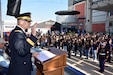 man in uniform holds up his right hand.