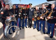 man poses with musicians holding instruments