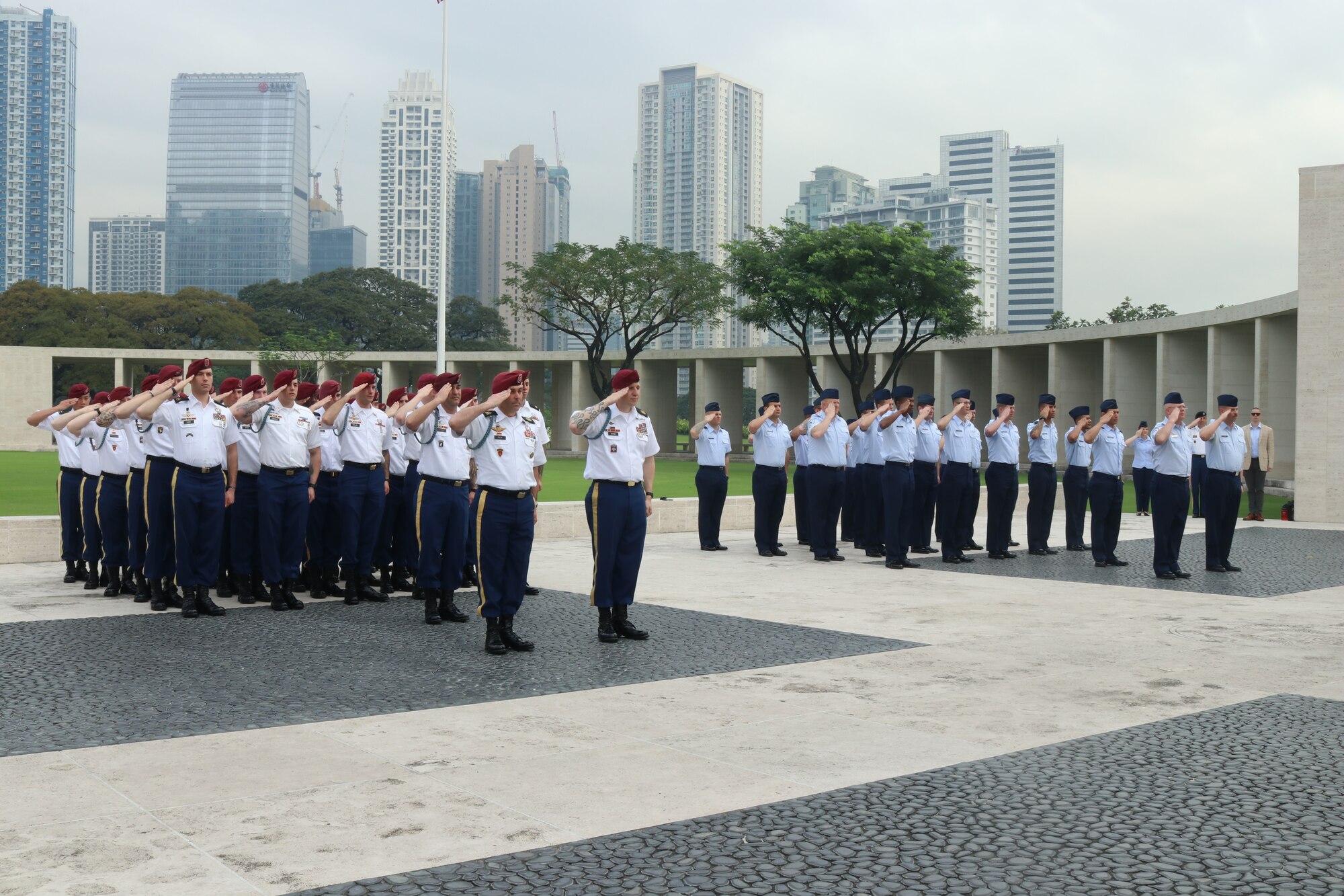 U.S. service members from the 317th Airlift Wing from Dyess Air Force Base, Texas, and the 2nd Battalion, 503rd Infantry Regiment in Vicenza, Italy, issue a salute during the playing of the U.S. national anthem in the 75th anniversary of the retaking of Corregidor Island ceremony at the Manila American Cemetery in Manila, Philippines, Feb. 17, 2020.