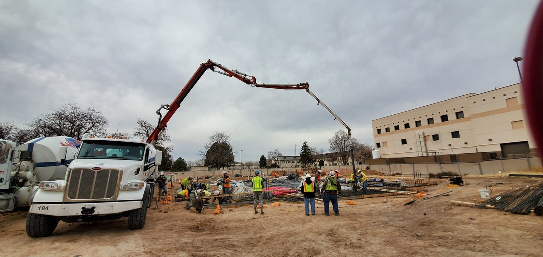 A concrete pump truck assists in placing concrete into footings for the future DeSel Facility at Kirtland Air Force Base, Dec. 23, 2019.