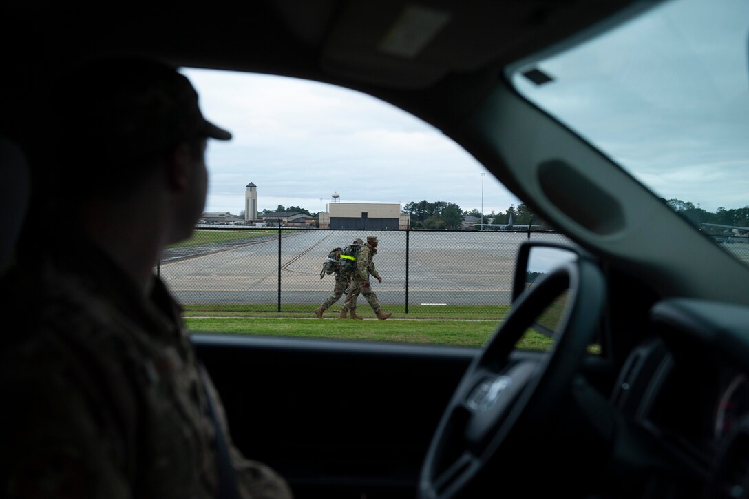 A photo of an Airmen watching others while they ruck march