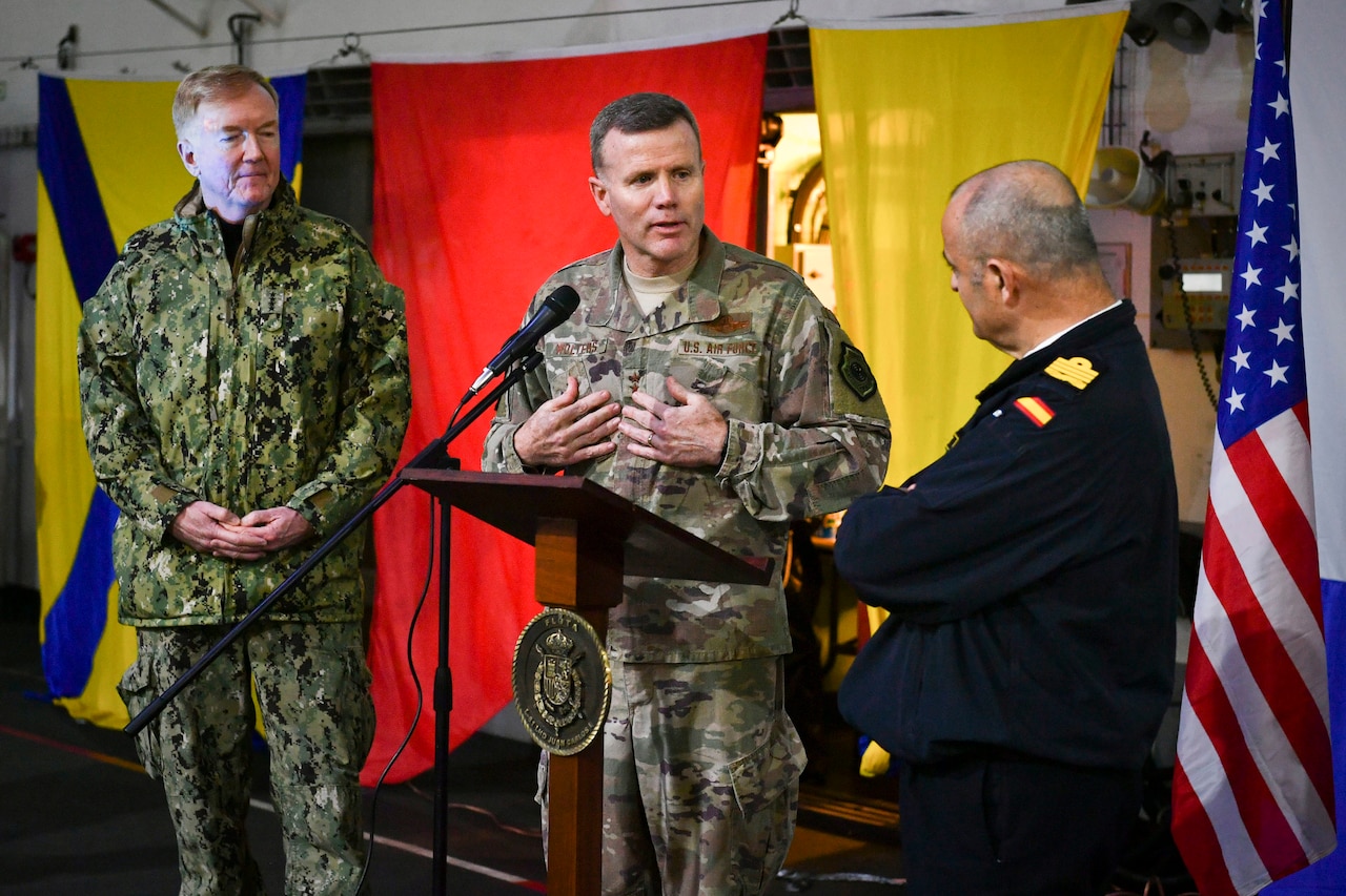 A group of military leaders stand and talk.