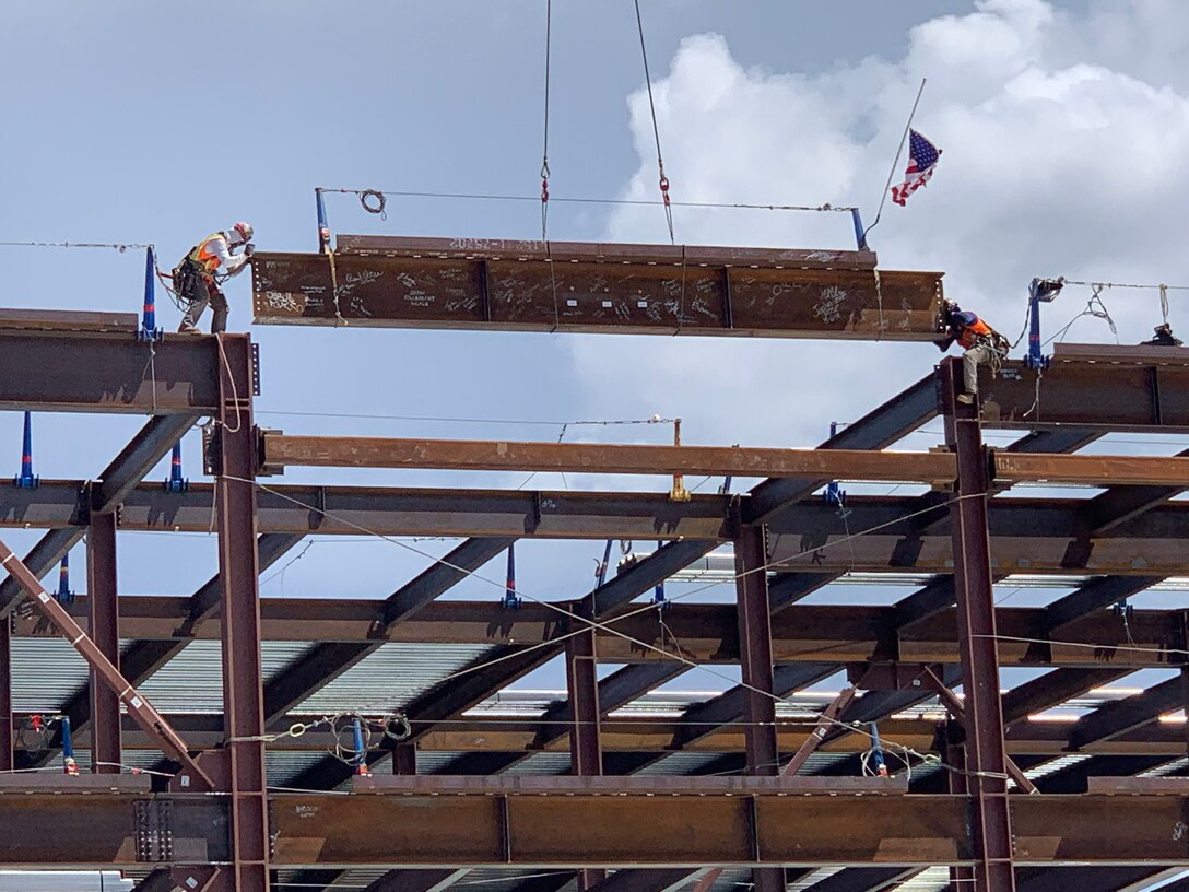 Workers maneuver the final structural beam in place during a Topping Out ceremony at the NNSA Albuquerque Complex, Aug. 6, 2019.