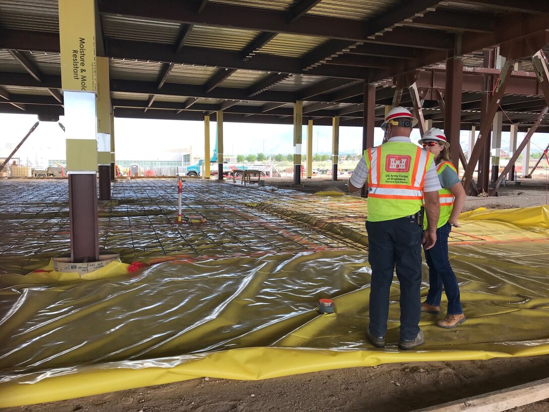 Garry Vollbrecht, construction control representative at the KAFB Resident Office, explains to Tracy Wolf, district safety manager, the procedures that have to take place prior to pouring concrete on the first floor of the NNSA Albuquerque Complex, Aug. 14, 2019.
