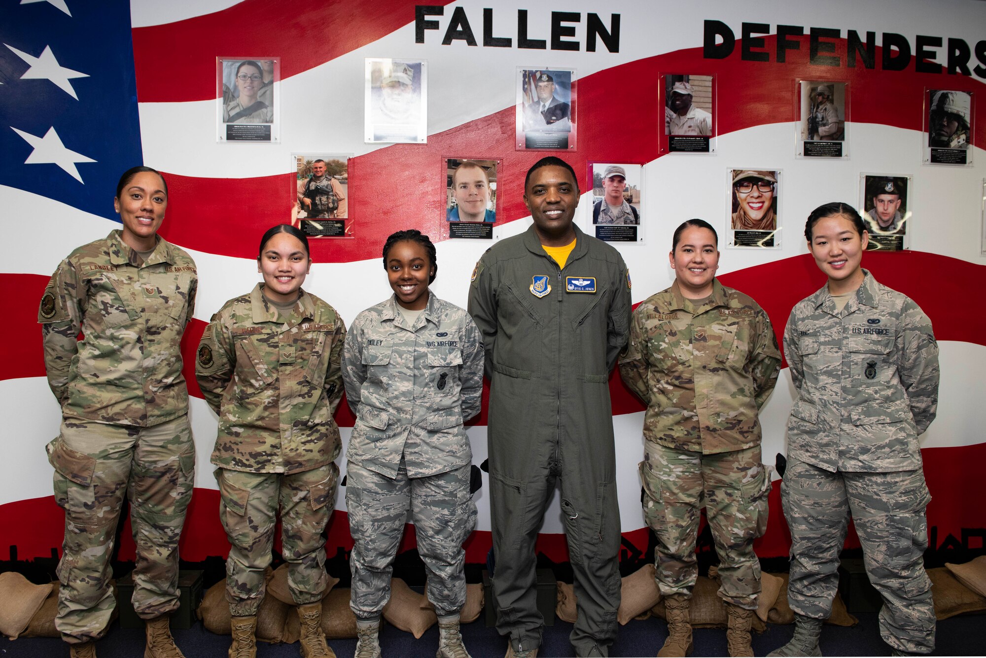 (Center) Col. Otis C. Jones, 374th Airlift Wing commander, poses for a photo after a mural unveiling ceremony with Airmen who created the mural at Yokota Air Base, Japan, Feb. 7, 2020.
