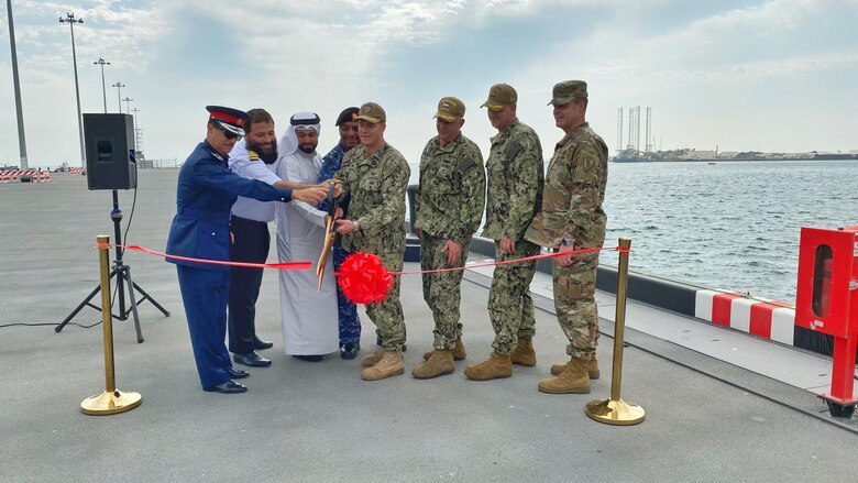 Capt. Greg Smith, commanding officer of Naval Support Activity (NSA) Bahrain, cuts a ribbon with senior American and Bahraini leaders to celebrate the opening of the renovated Mina Salman Pier. NSA Bahrain enables the forward operations and responsiveness of U.S. and allied forces in support of Navy Region Europe, Africa, Central’s mission to provide services to the fleet, warfighter and family