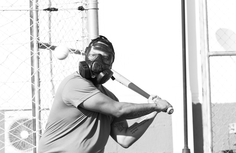 A U.S. Army Soldier, with 655 Regional Support Group, 316 Sustainment Command (Expeditionary), 377 Theater Sustainment Command,  prepares to swing at a ball during a game of gas mask baseball Feb. 12, 2020 at Joint Training Center-Jordan, paying tribute to former service members who used the sport to train for chemical warfare during WWI. We still have the greatest Army in the world. We serve the people of the United States and we are going to protect them with our lives if that is what it comes to. (U.S. Army photo by Sgt. 1st Class Shaiyla B. Hakeem)