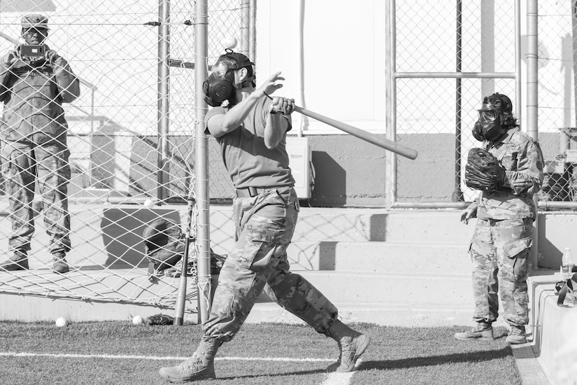 A U.S. Army Soldier, with 655 Regional Support Group, 316 Sustainment Command (Expeditionary), 377 Theater Sustainment Command, swings at a ball during a game of gas mask baseball Feb. 12, 2020 at Joint Training Center-Jordan, paying tribute to former service members who used the sport to train for chemical warfare during WWI. We still have the greatest Army in the world. We serve the people of the United States and we are going to protect them with our lives if that is what it comes to. (U.S. Army photo by Sgt. 1st Class Shaiyla B. Hakeem)
