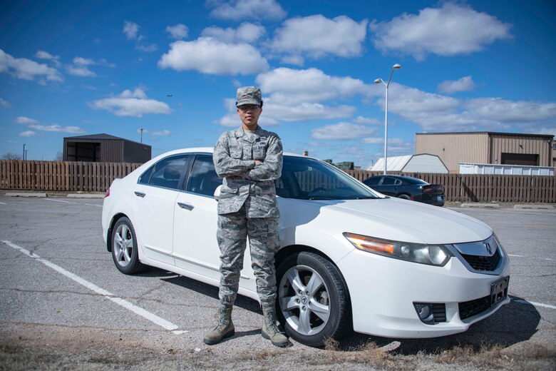 person stands in front of a car