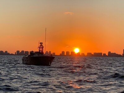 The Unmanned Influence Sweep System (UISS) heads offshore at sunrise for an Operational Assessment mission off the coast of South Florida in November 2019. The UISS consists of an unmanned surface vehicle and a towed minesweeping payload for influence sweeping of magnetic, acoustic and magnetic/acoustic combination mine types while keeping warfighters out of the minefield.