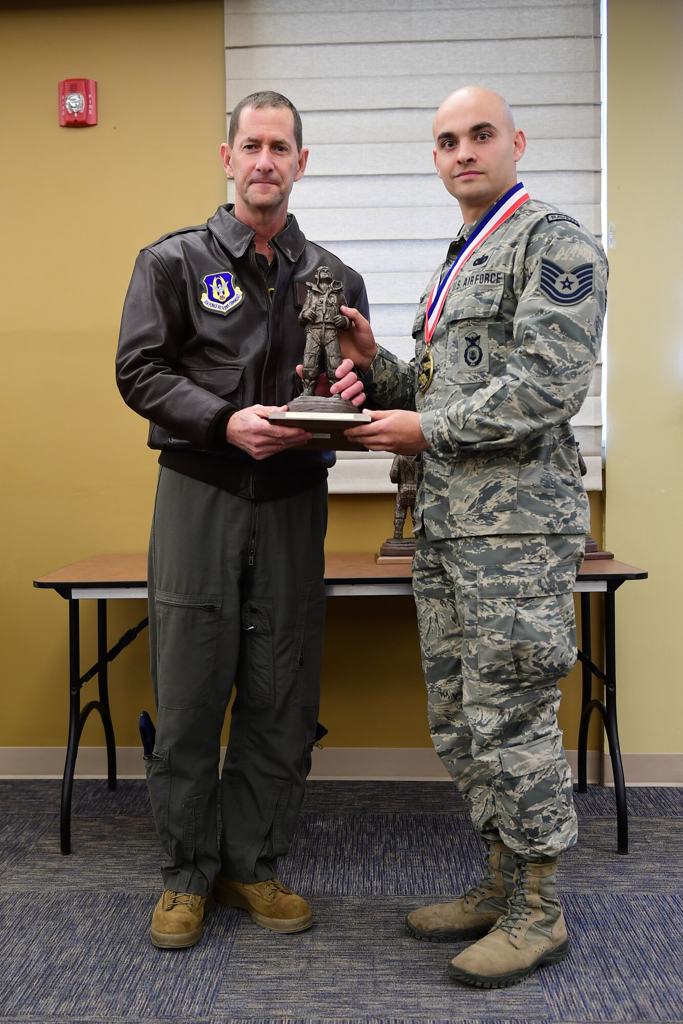 Col. John F. Robinson, commander of the 911th Airlift Wing, presents Tech. Sgt. Jacob A. Stokes, fire team member with the 911th Security Forces Squadron, with the NCO of the Year award at the Pittsburgh International Airport Air Reserve Station, Pennsylvania, Feb. 8, 2020.