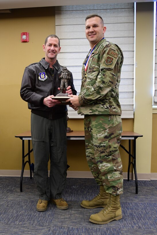 Col. John F. Robinson, commander of the 911th Airlift Wing, presents 1st Lt. Ryan L. Scott, officer in charge of the 911th Logistics Readiness Squadron, with the Company Grade Officer of the Year award at the Pittsburgh International Airport Air Reserve Station, Pennsylvania, Feb. 8, 2020.