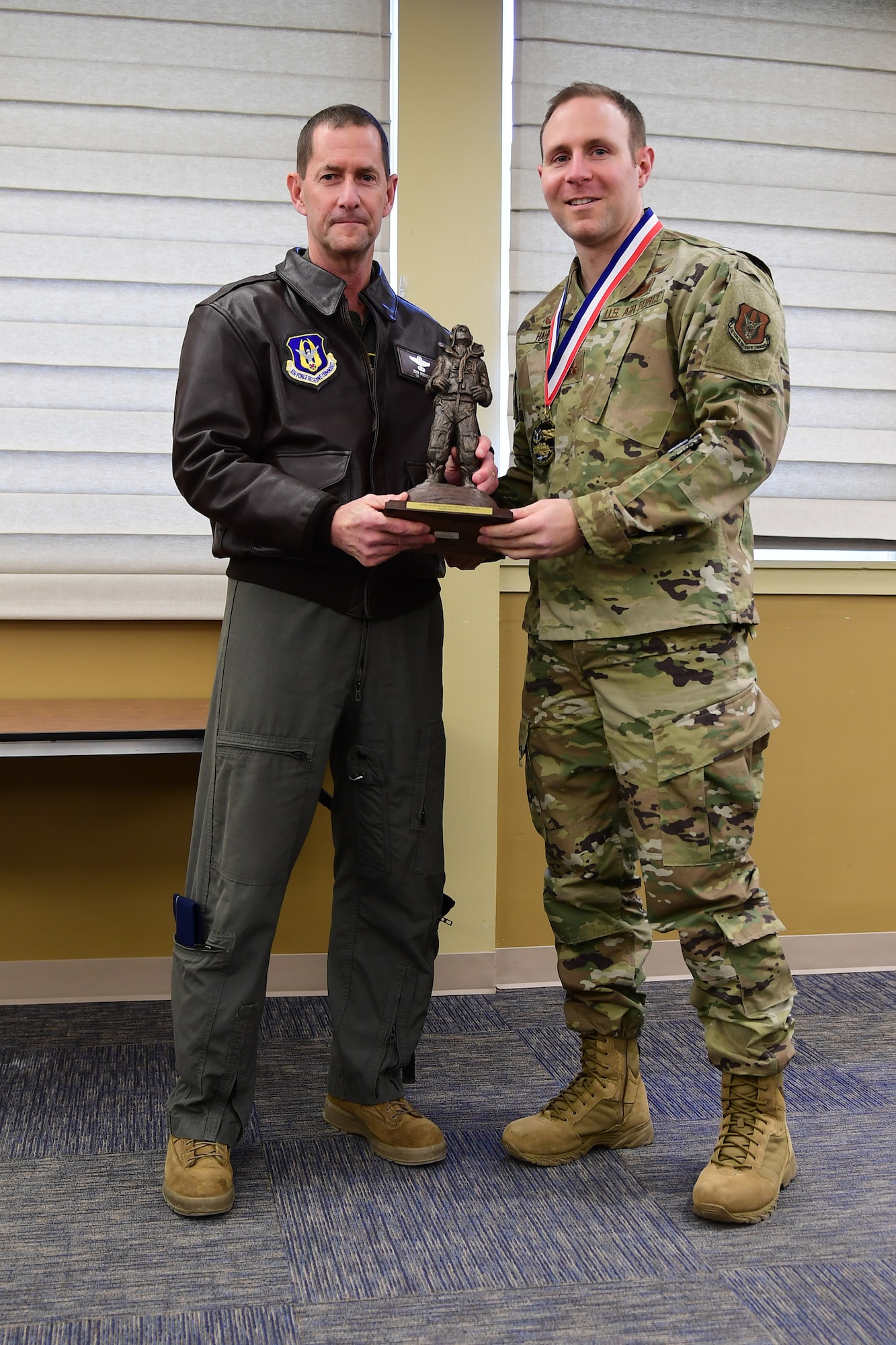 Col. John F. Robinson, commander of the 911th Airlift Wing, presents Maj. Philip C. Hahn, Commander of the 911th Communications Squadron, with the Field Grade Officer of the Year award at the Pittsburgh International Airport Air Reserve Station, Pennsylvania, Feb. 8, 2020.