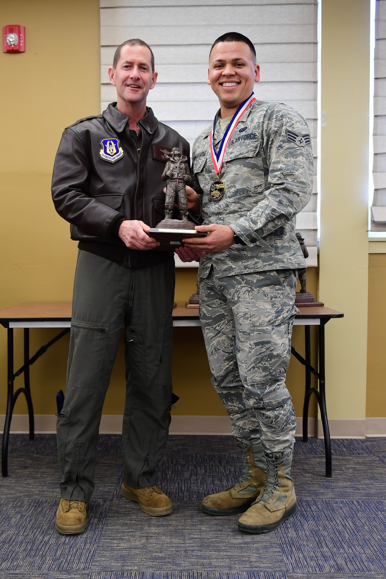 Col. John F. Robinson, commander of the 911th Airlift Wing, presents Senior Airman Jeffrey Morales Rosa, client systems technician with the 911th Communications Squadron, with the Airman of the Year award at the Pittsburgh International Airport Air Reserve Station, Pennsylvania, Feb. 8, 2020.