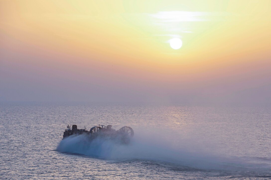 A Navy ship moves through waters.