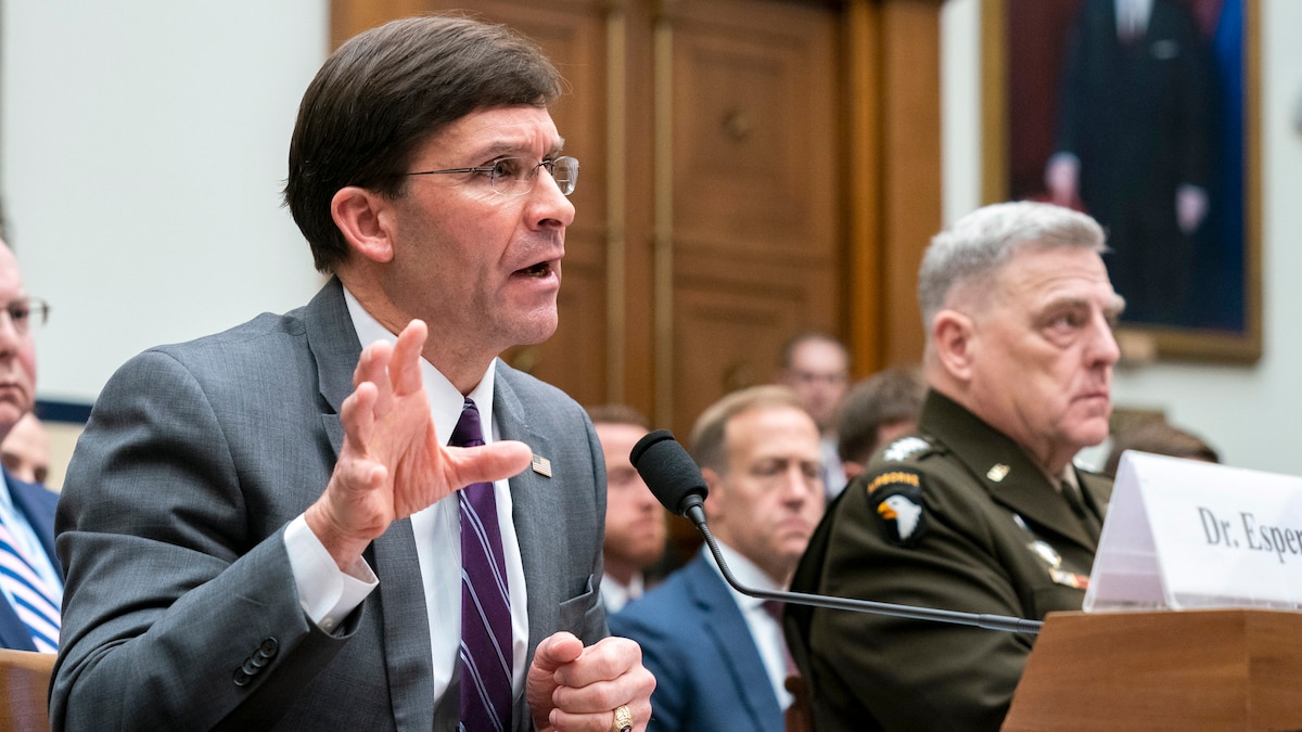 Defense Secretary Dr. Mark T. Esper sits at a table. 