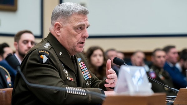 Army Gen. Mark A. Milley sits and speaks at a table.