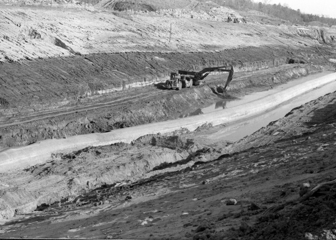 Crews remove soil during construction of the Tennessee-Tombigbee Waterway in Mississippi April 4, 1978. It took over 100-million dump truck loads of soil to connect the Tennessee and Tombigbee Rivers, opening a new passageway to the Gulf of Mexico in 1985. The Mobile District constructed the southern 195 miles of the Tennessee-Tombigbee Waterway, including nine locks and dams. The Nashville District excavated the northern 29 miles of the project, including the massive 27-mile divide cut, which connected the waterway with Pickwick Lake on the Tennessee River.  The Corps excavated nearly 310 million cubic yards of soil during the 12-year project.  In comparison, 210-million cubic yards of earth were removed from the Panama Canal.  In the end, the two districts, 125 prime contractors and 1,200 subcontractors worked on the overall waterway. The 10 locks and five dams required a total of 2.2 million cubic yards of concrete and 33,000 tons of reinforcing steel. (USACE Historical Photo)