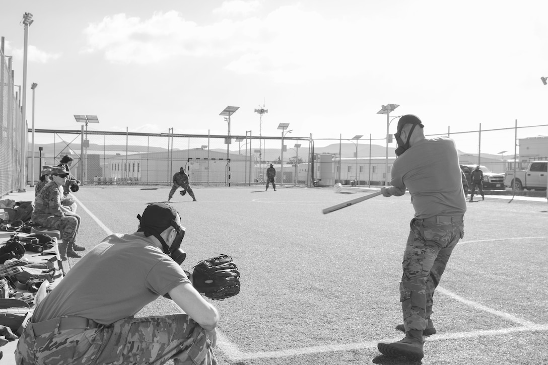 A U.S. Army Soldier, with 655 Regional Support Group, 316 Sustainment Command (Expeditionary), 377 Theater Sustainment Command, swings at a ball during a game of gas mask baseball Feb. 12, 2020 at Joint Training Center-Jordan, paying tribute to former service members who used the sport to train for chemical warfare during WWI. We still have the greatest Army in the world. We serve the people of the United States and we are going to protect them with our lives if that is what it comes to. (U.S. Army photo by Sgt. 1st Class Shaiyla B. Hakeem)