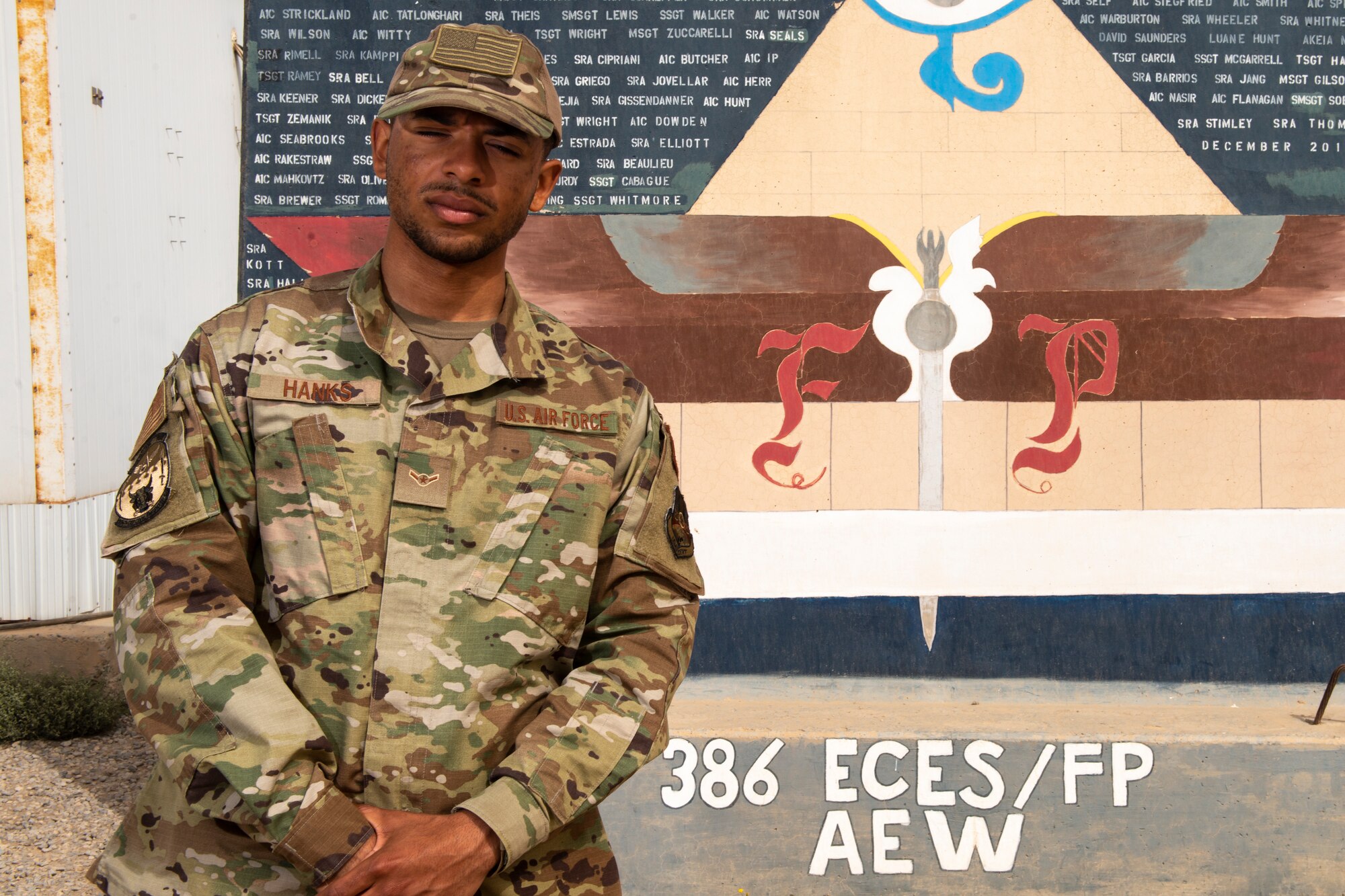 Airman Antwain Hanks, 386th Expeditionary Civil Engineer Squadron force protection, poses for a photo in front of an FP mural at Ali Al Salem Air Base, Kuwait, Feb. 26, 2020. Hanks is originally a photojournalist from the 366th Fighter Wing Public Affairs office at Mountain Home Air Force Base, Idaho. (U.S. Air Force photo by Senior Airman JaNae Capuno)