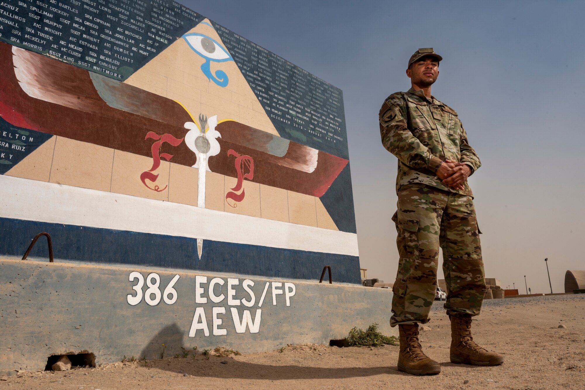 Airman Antwain Hanks, 386th Expeditionary Civil Engineer Squadron force protection, poses for a photo in front of an FP mural at Ali Al Salem Air Base, Kuwait, Feb. 26, 2020. Hanks is originally a photojournalist from the 366th Fighter Wing Public Affairs office at Mountain Home Air Force Base, Idaho. (U.S. Air Force photo by Senior Airman JaNae Capuno)